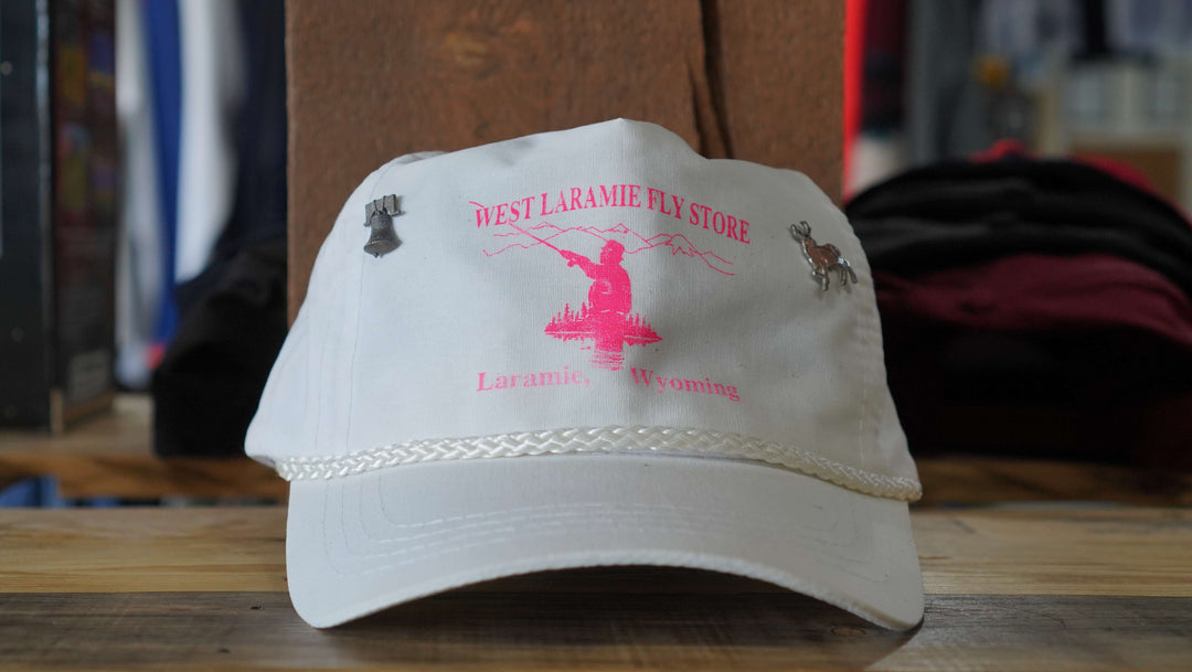 Vintage West Laramie Fly Store rope hat from the 90s, white with pink fly fishing print, from West Block Vintage, perfect for outdoor enthusiasts and collectors.