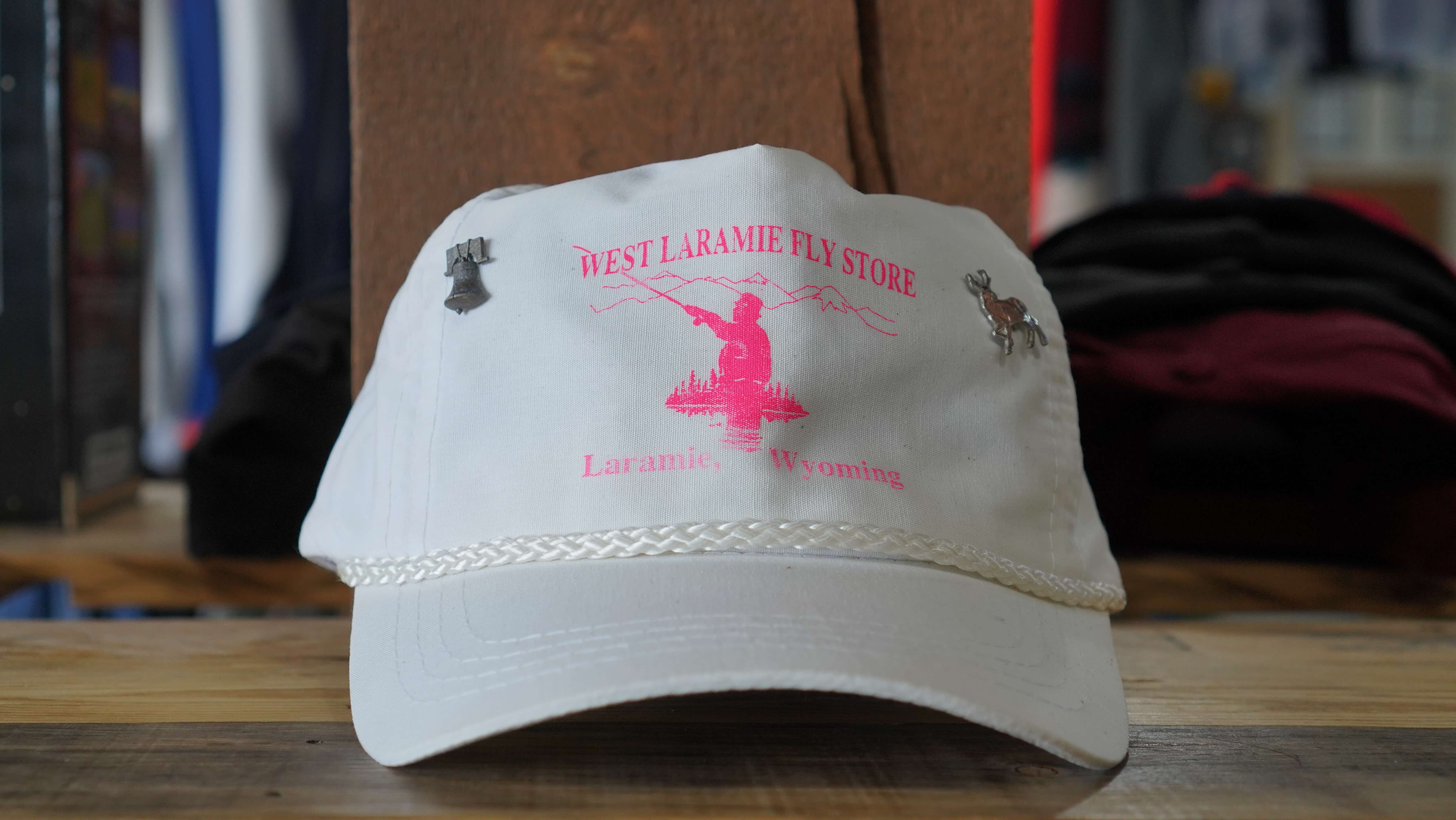 Vintage West Laramie Fly Store rope hat from the 90s, white with pink fly fishing print, from West Block Vintage, perfect for outdoor enthusiasts and collectors.