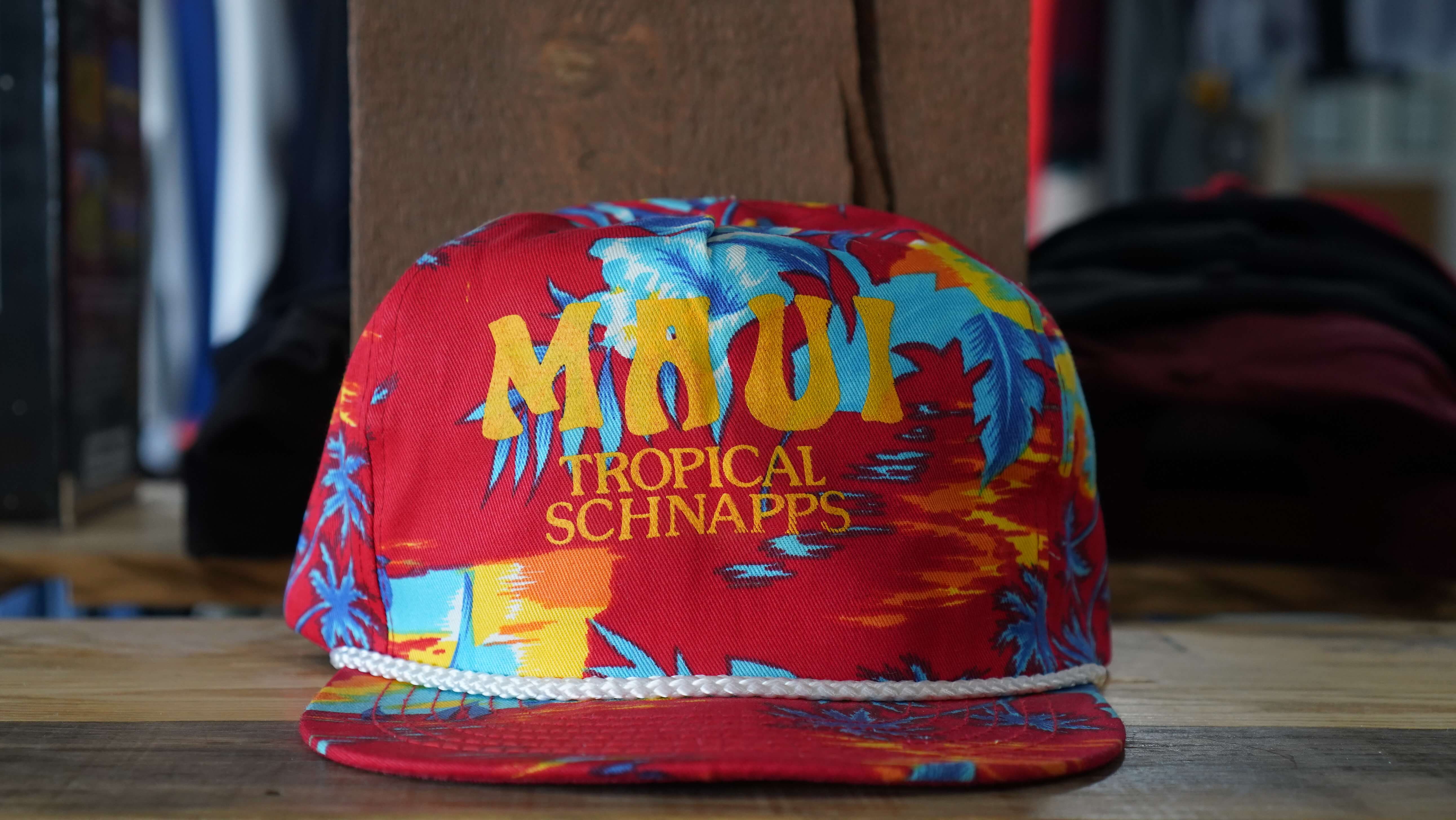 Vintage Maui Tropical Schnapps red rope hat with vibrant floral and tropical patterns, from West Block Vintage—perfect for fans of unique beverage and floral trucker hats.