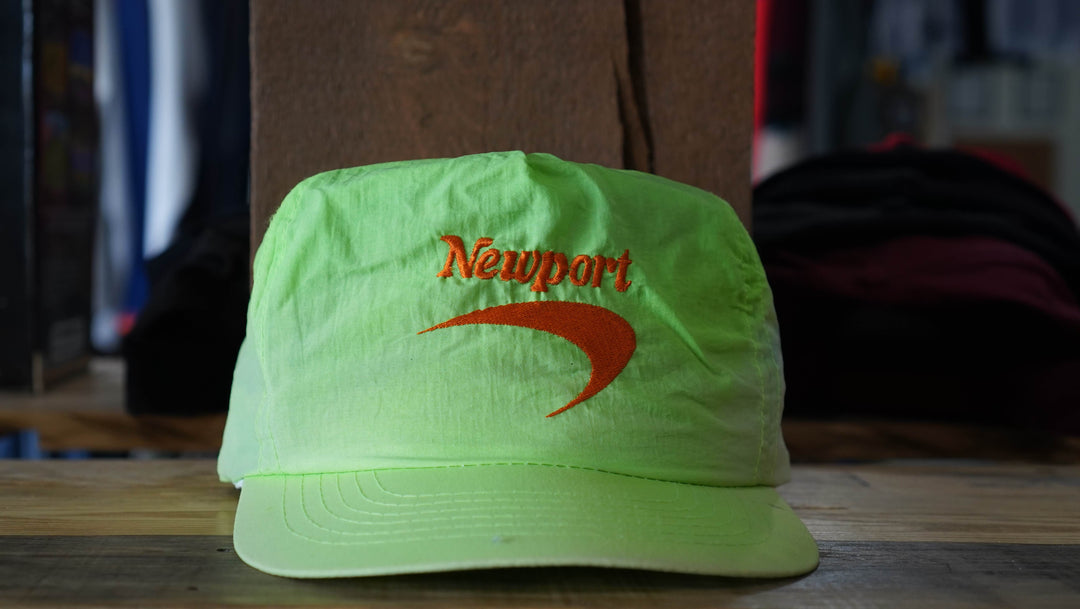 Green Newport promotional trucker hat with vibrant orange logo, from West Block Vintage—ideal for enthusiasts and collectors of standout 90s country trucker hats.