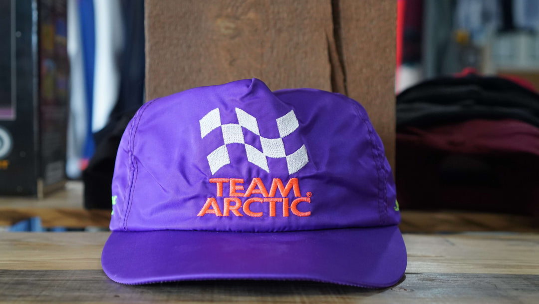 Team Arctic Cat purple trucker hat with checkered flag pattern, from West Block Vintage—perfect for enthusiasts of racing-inspired country trucker hats.